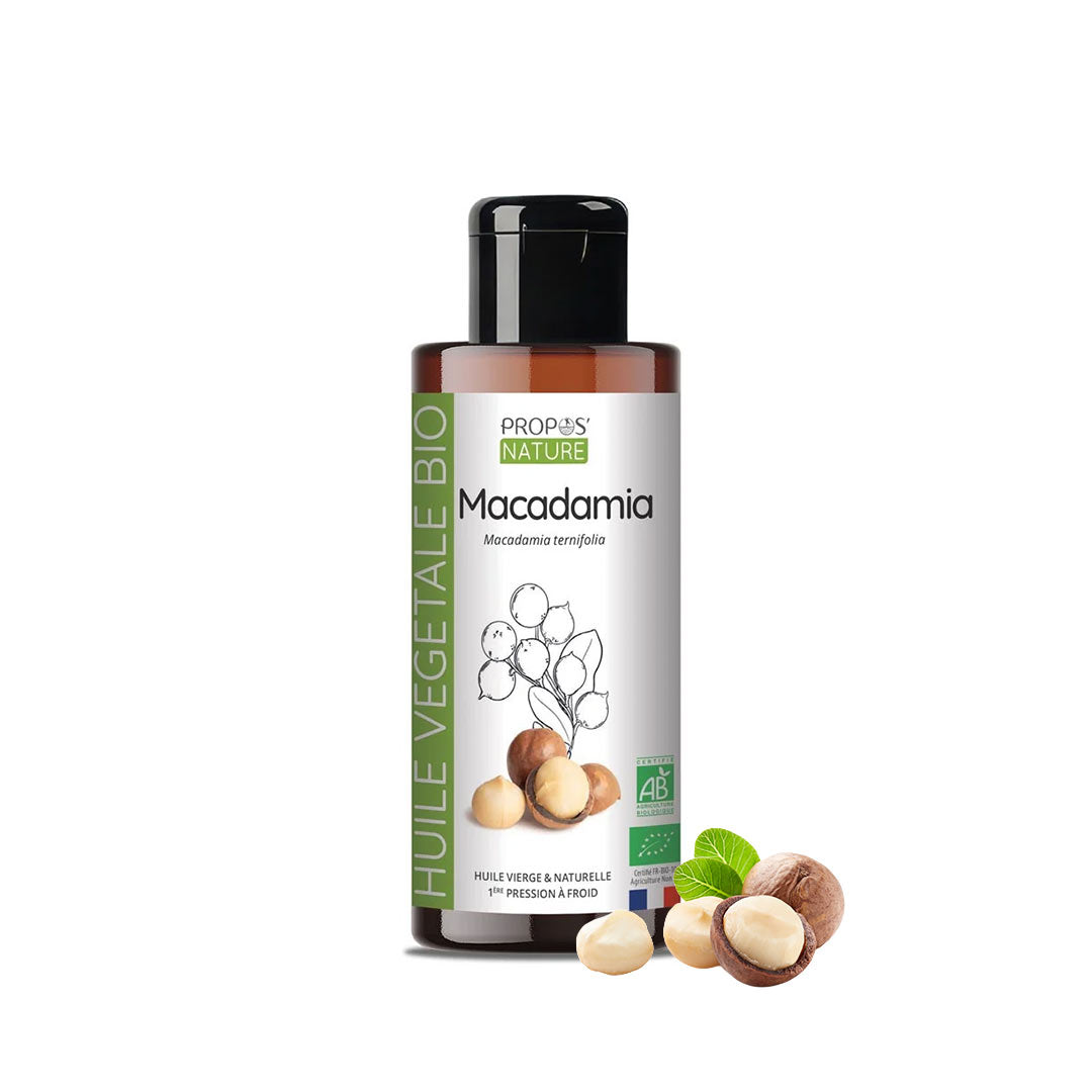 A bottle of Propos Nature Macadamia vegetable oil with a black cap and white label, shown on a white background with macadamia nuts and leaves at the base.