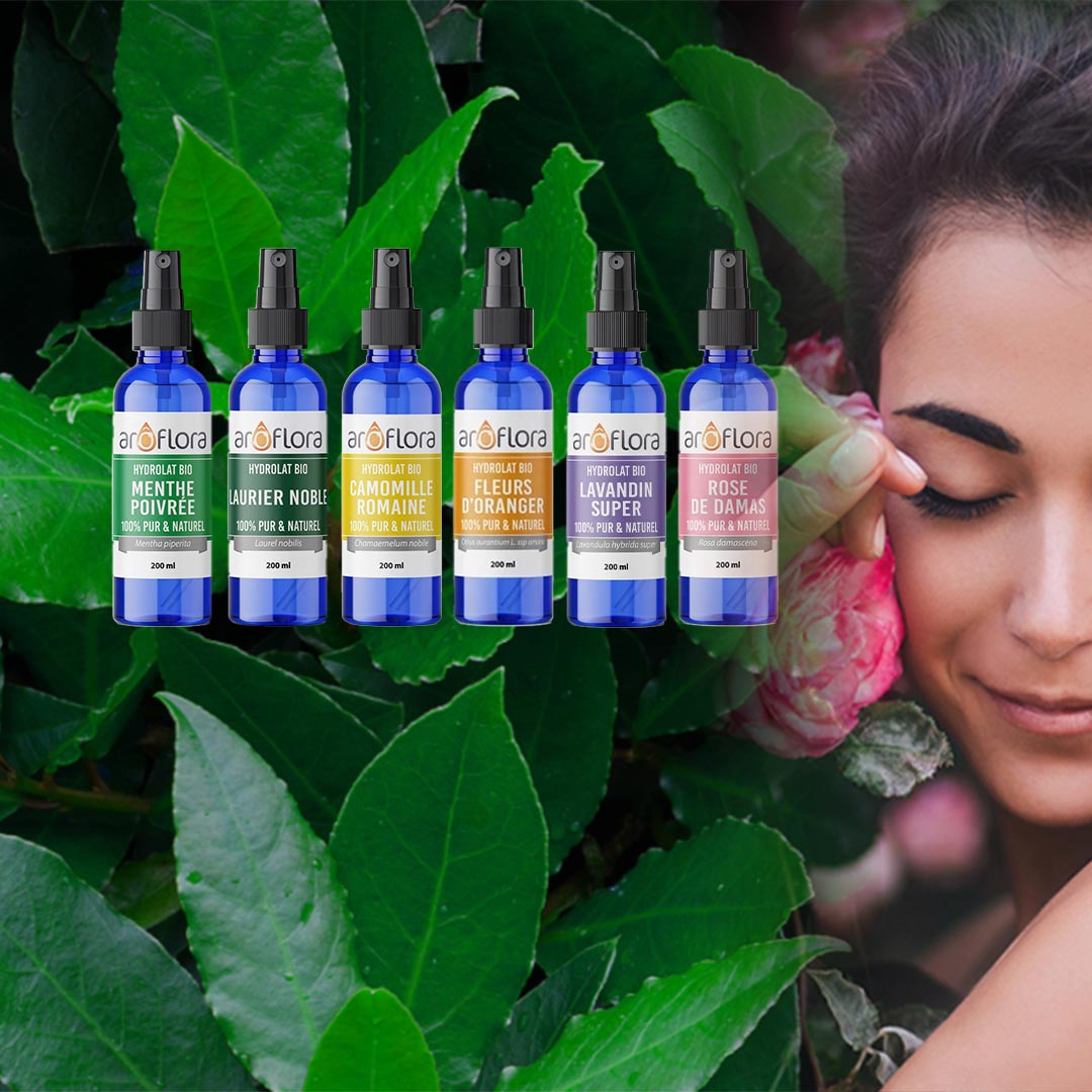 Food grade hydrosols of Peppermint, Bay Laurel, Roman Chamomile, Neroli, Lavandin Super and Rosa Damask on a background of Bay Laurel and a woman caressing a rose