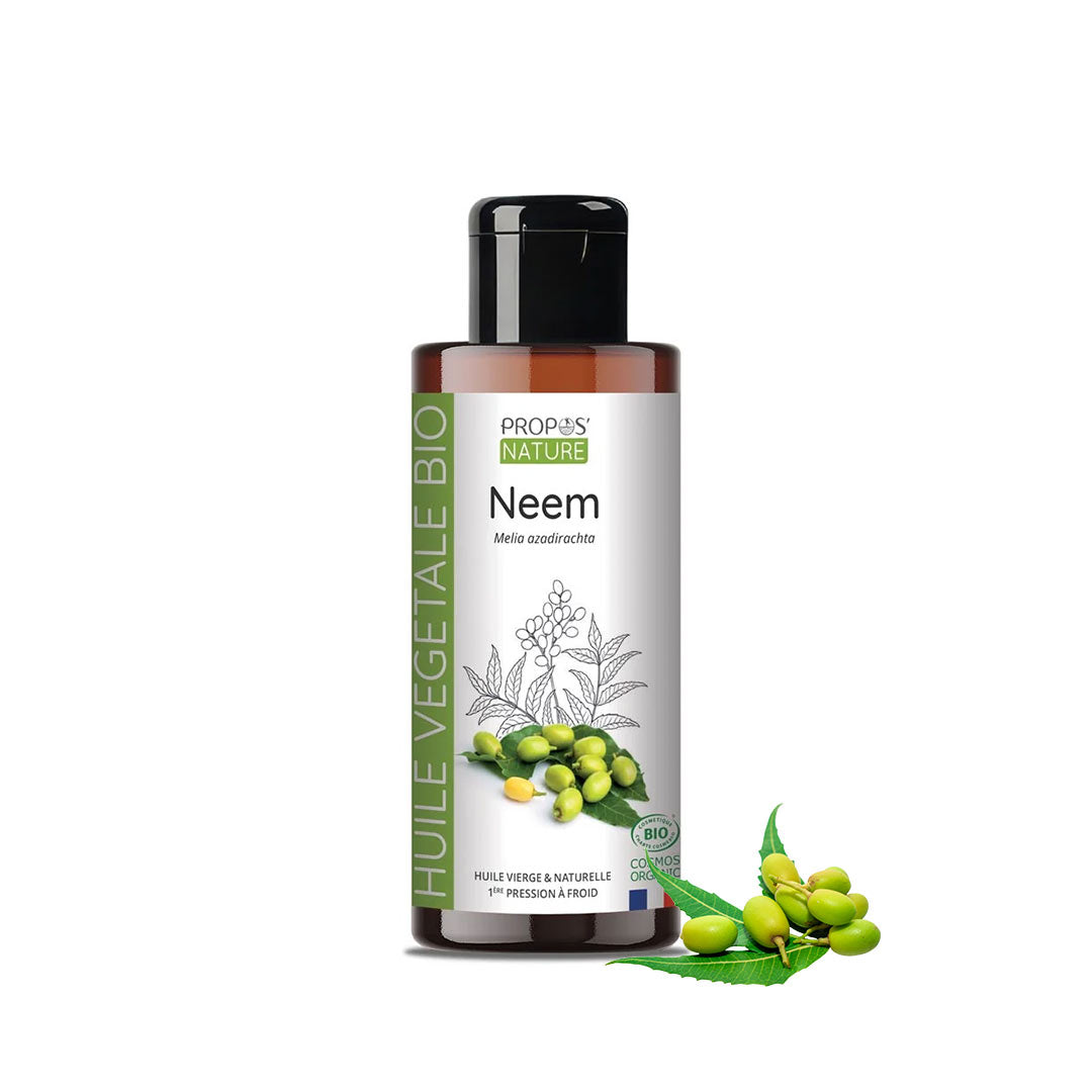 A bottle of Propos Nature Neem vegetable oil with a black cap and white label, shown on a white background with neem green leaves and seeds as a decorative element.