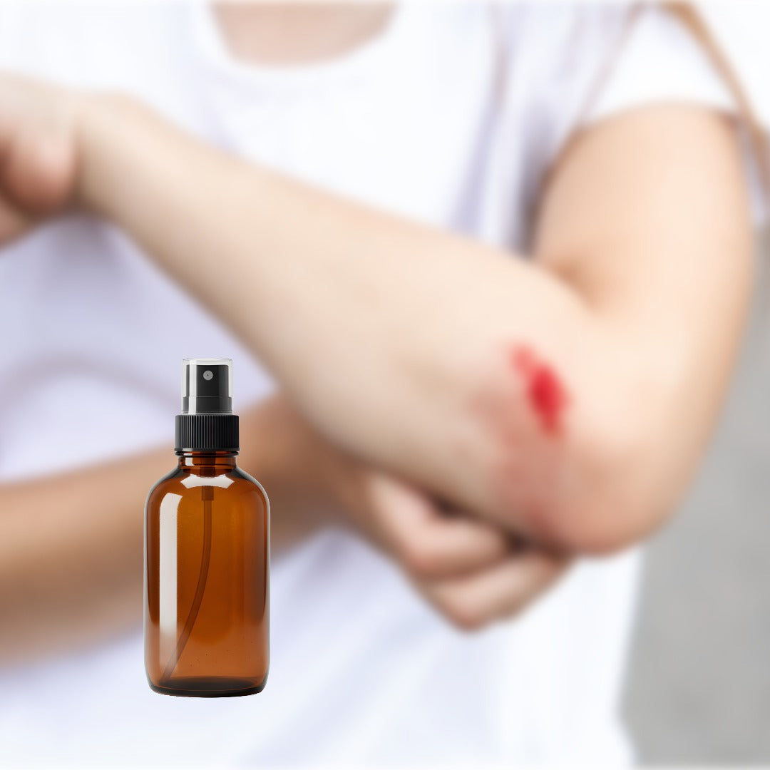 Brown spray bottle in front of a child's arm with a wound in a blurry background