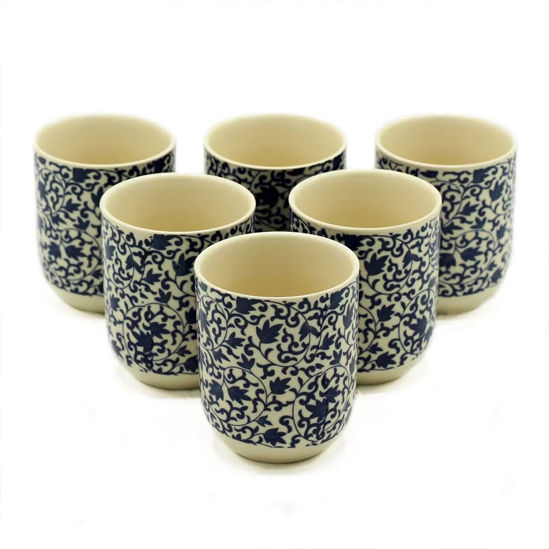Set of six ceramic cups with blue floral patterns on a white background