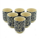 Set of six ceramic cups with blue floral patterns on a white background