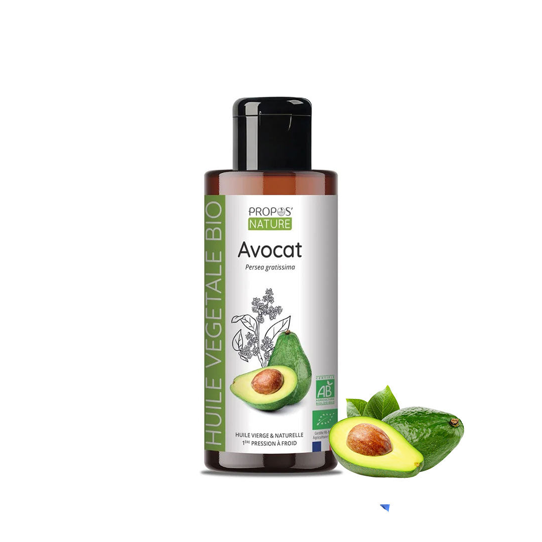 A bottle of Propos Nature Avocat (avocado) vegetable oil with a black cap and white label, shown alongside fresh green avocado halves and leaves on a plain white background.