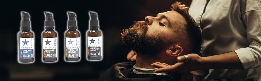 a man with beard sitting and leaning back to get his beard taken care of, 4 bottles of Ancient Wisdom Beard Oils in the upper left corner
