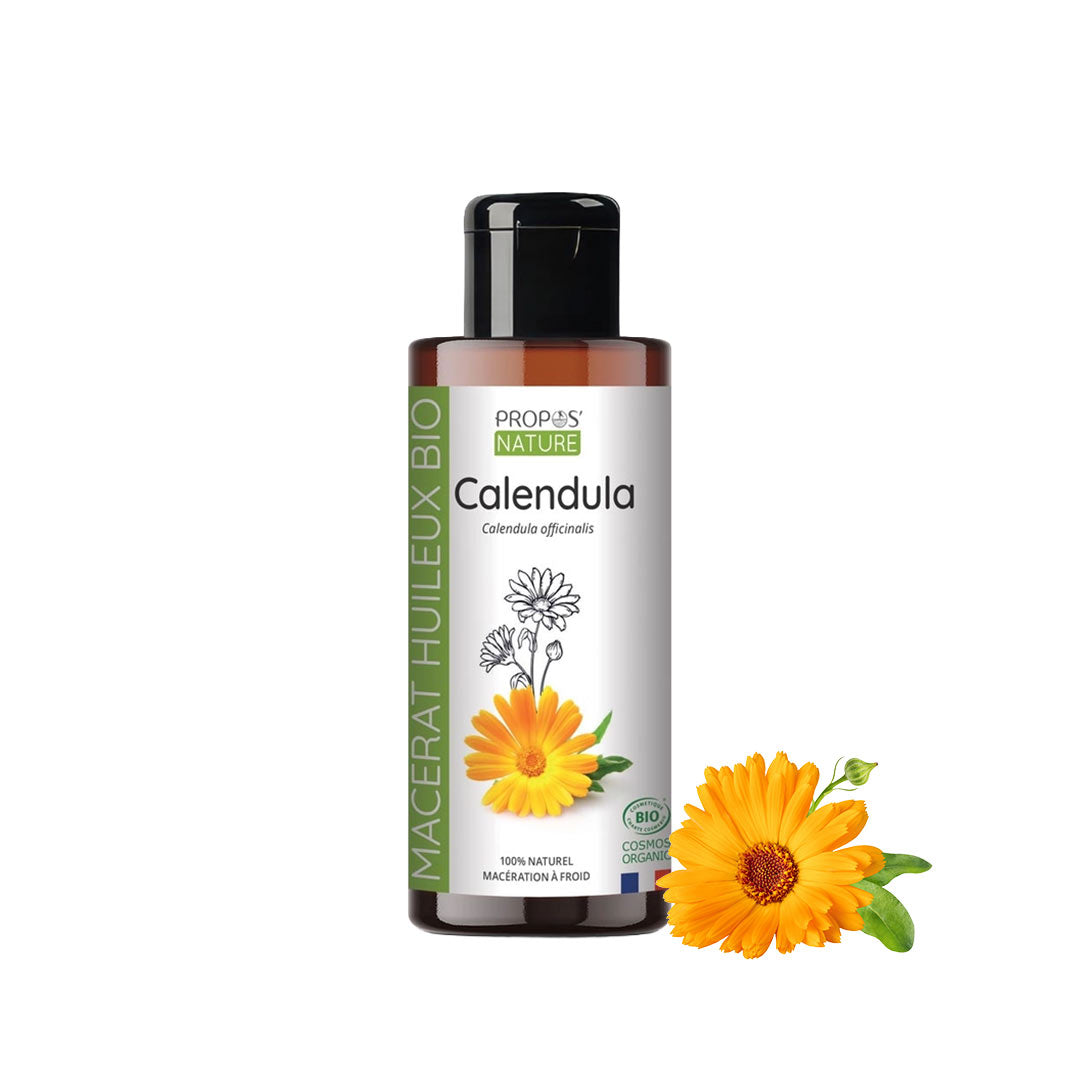 Bottle of Propos Nature Calendula oil with calendula flowers on a white background