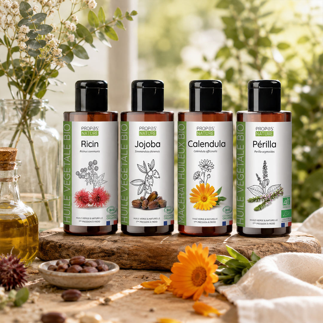 Four bottles of Propos'Nature bio oils (Ricin, Jojoba, Calendula, and Périlla) arranged on a rustic wooden board with natural ingredients and green foliage in the background.