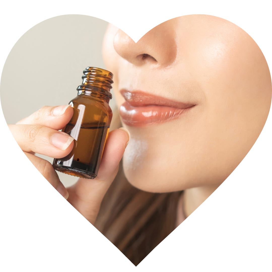 A woman smelling a bottle of essential oil