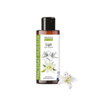 A bottle of Propos Nature Macerat  Lys (lily of the valley oil) with a black cap and white label, shown next to a white lily flower on a plain white background.