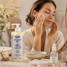 A woman applies liniment to her face while standing in a bathroom setting. In the foreground, a bottle of Liniment Bio 