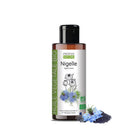 A bottle of Propos Nature 'Nigelle' vegetable oil on a white background, styled with a blue black cumin flower and a small sprig of nigelle seeds at the base.