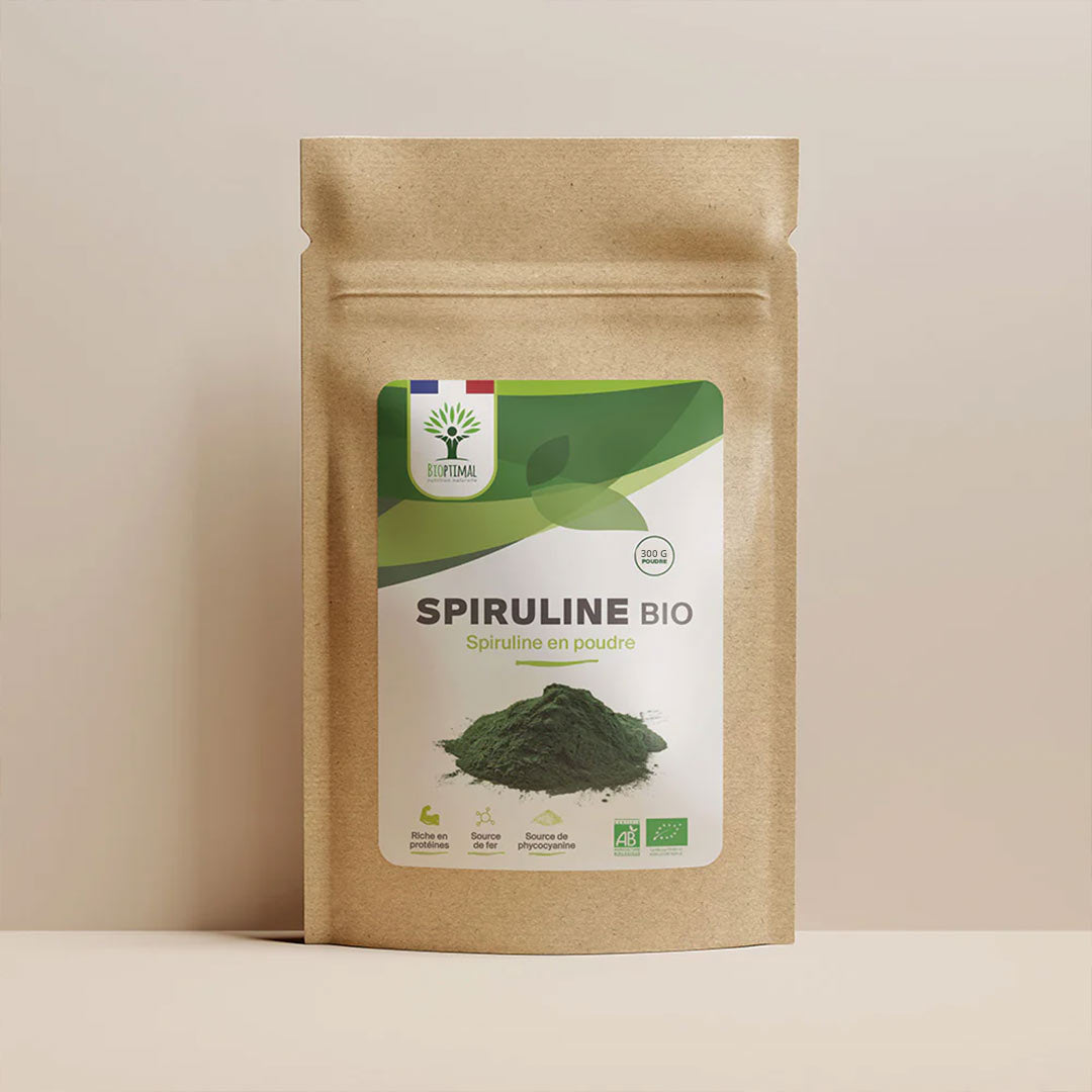 A stand-up kraft paper pouch of Spirulina Bio powder with a green and white label, photographed against a plain beige studio background.