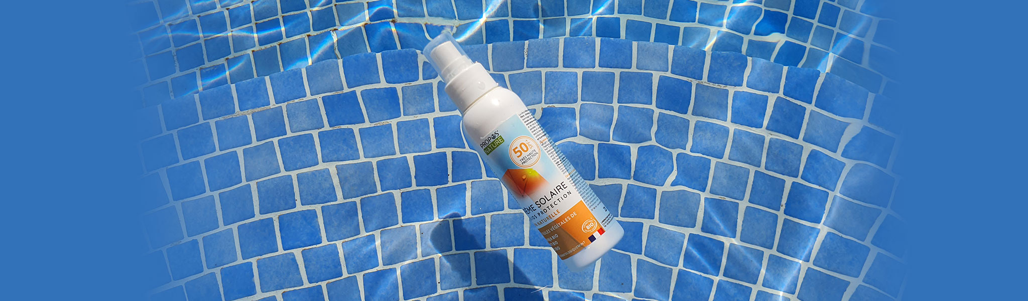 A bottle of Propos Nature Sunscreen floating in the pool